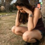 Stress - Photo of a Woman Crouching while Her Hands are on Her Head