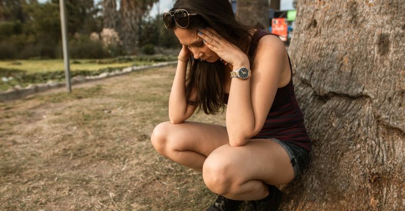 Stress - Photo of a Woman Crouching while Her Hands are on Her Head