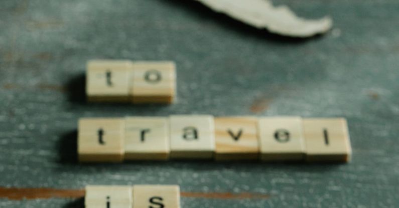 Vintage Pieces - Scrabble Tiles and a Piece of a World Map in a Wooden Surface