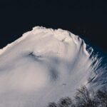 Night Routine - A snow covered mountain with trees in the background