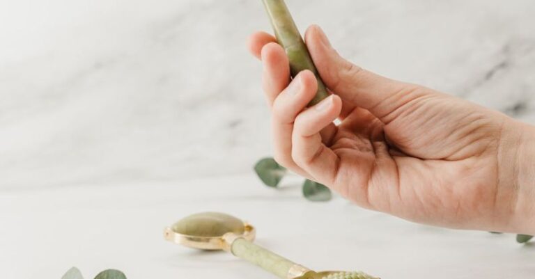 Jade Roller - Person Holding Silver Spoon With White Flower Petals