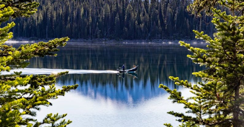 Micro-needling - A mountain is reflected in a lake with pine trees