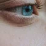 Eyebrow Shaping - Closeup side view of crop anonymous wistful female looking away with turquoise eye and black eyelashes with brown eyebrows and pores on face skin